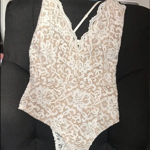White lace body suit with clips at the bottom